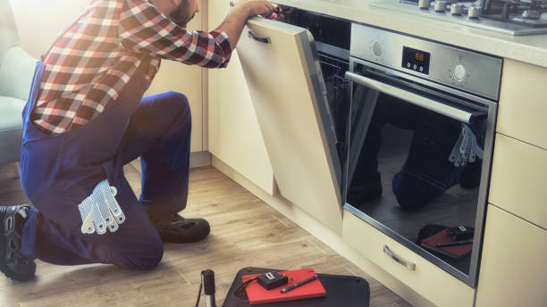 Service man fixing dishwasher machine at home kitchen